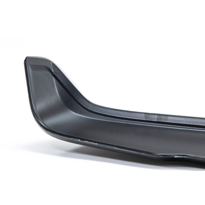 Close-up of a sleek, black car spoiler, showcasing its curved design and smooth surface, set against a white background.